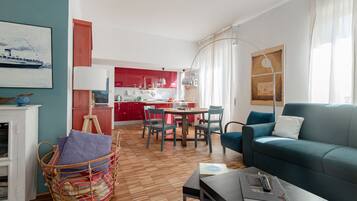Un salon moderne avec un canapé, une table à manger et une cuisine en arrière-plan.