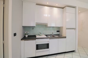 Eine moderne Küche mit weißen Schränken, einem eingebauten Backofen und einem Spülbecken.