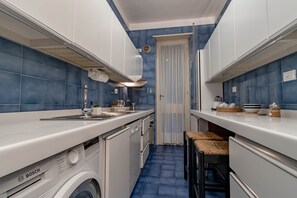 A compact kitchen with a Bosch washing machine, a sink, and a stove. - SANREMO VISTA MARE - Elegante (Sanremo)