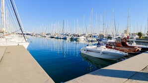 A marina with numerous boats docked along the water's edge.