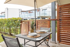An outdoor dining area with a table, chairs, and a wooden fence.