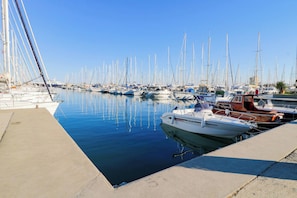 A marina with multiple boats docked along the water's edge.