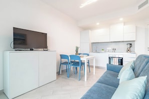 A modern apartment with a dining area, kitchen, and living room.