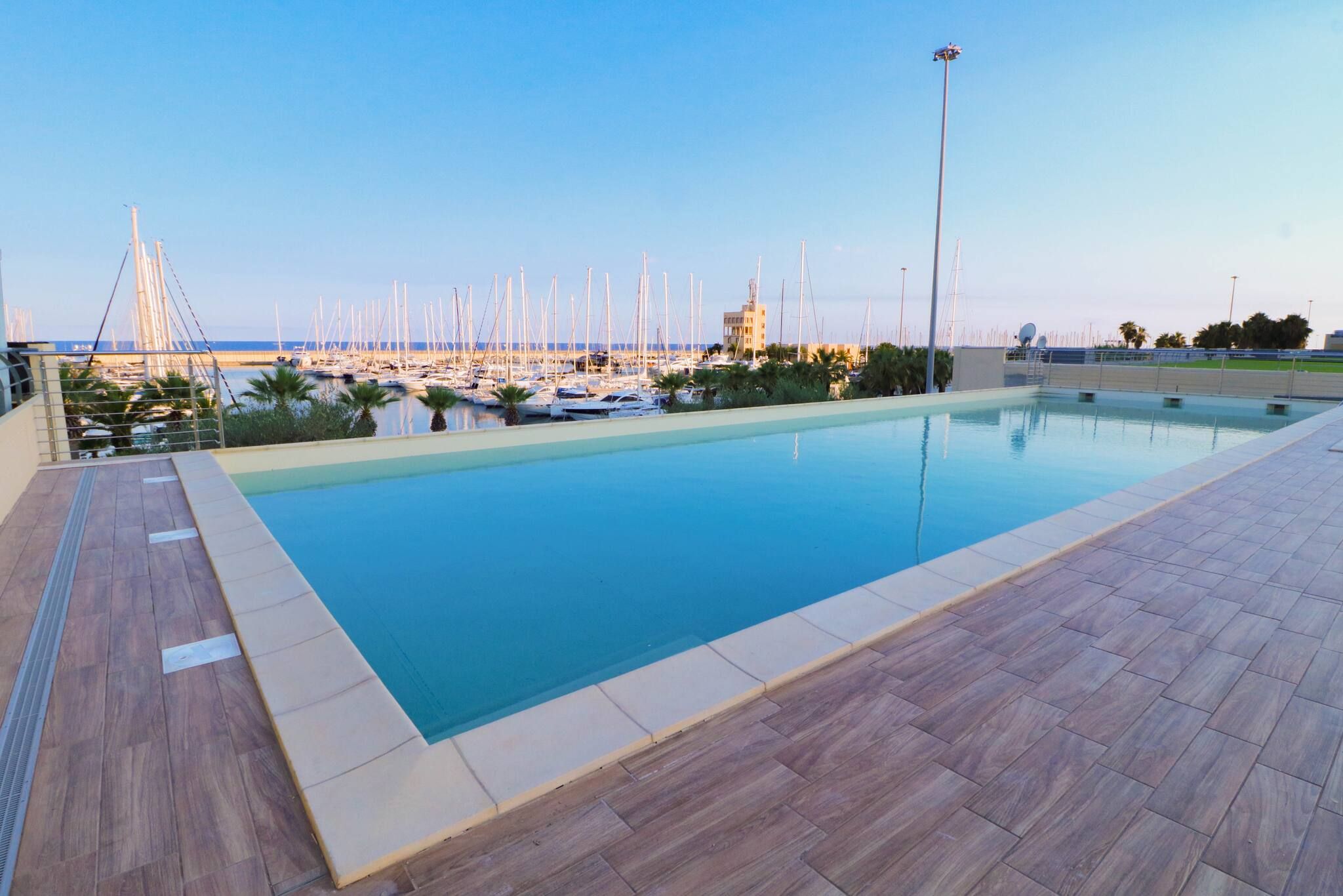 A swimming pool with a view of a marina and boats.