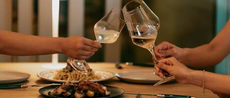 Una mesa de comedor con platos de comida, vasos y cubiertos.