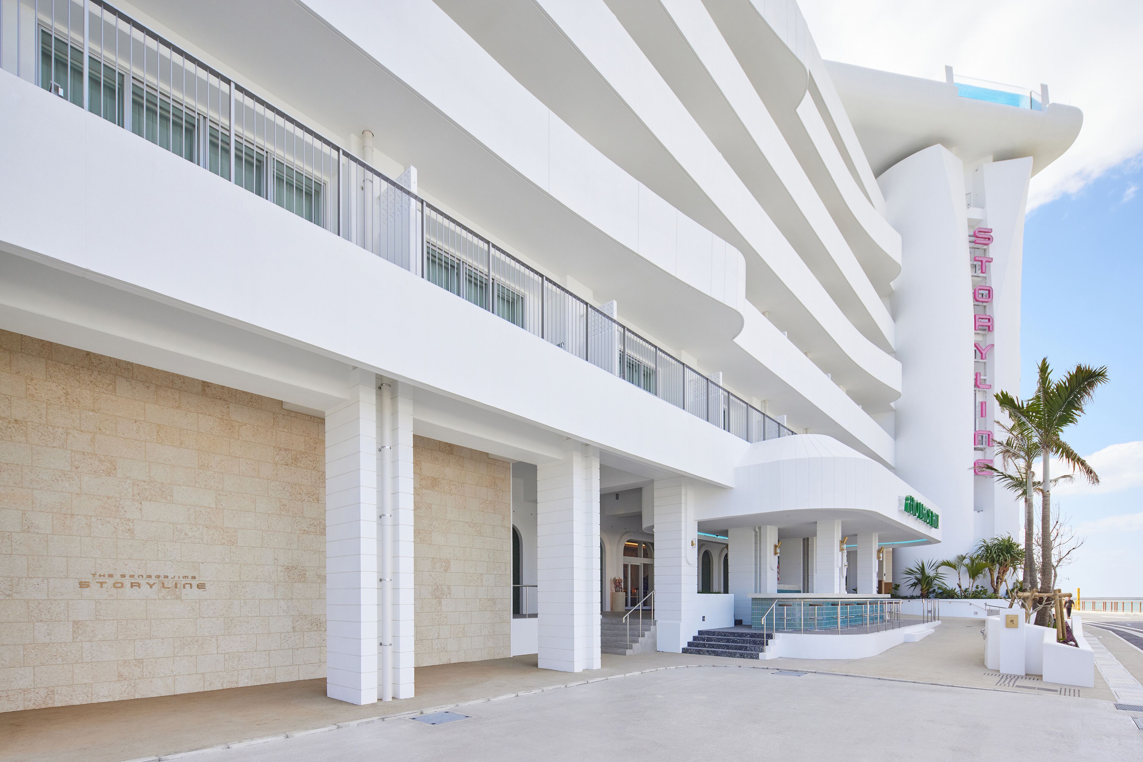 Un hotel moderno con varios pisos, una escalera destacada y un área de piscina.