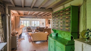 Une pièce avec un meuble vert, un coin repas et une vue sur l’extérieur, visible à travers une porte.