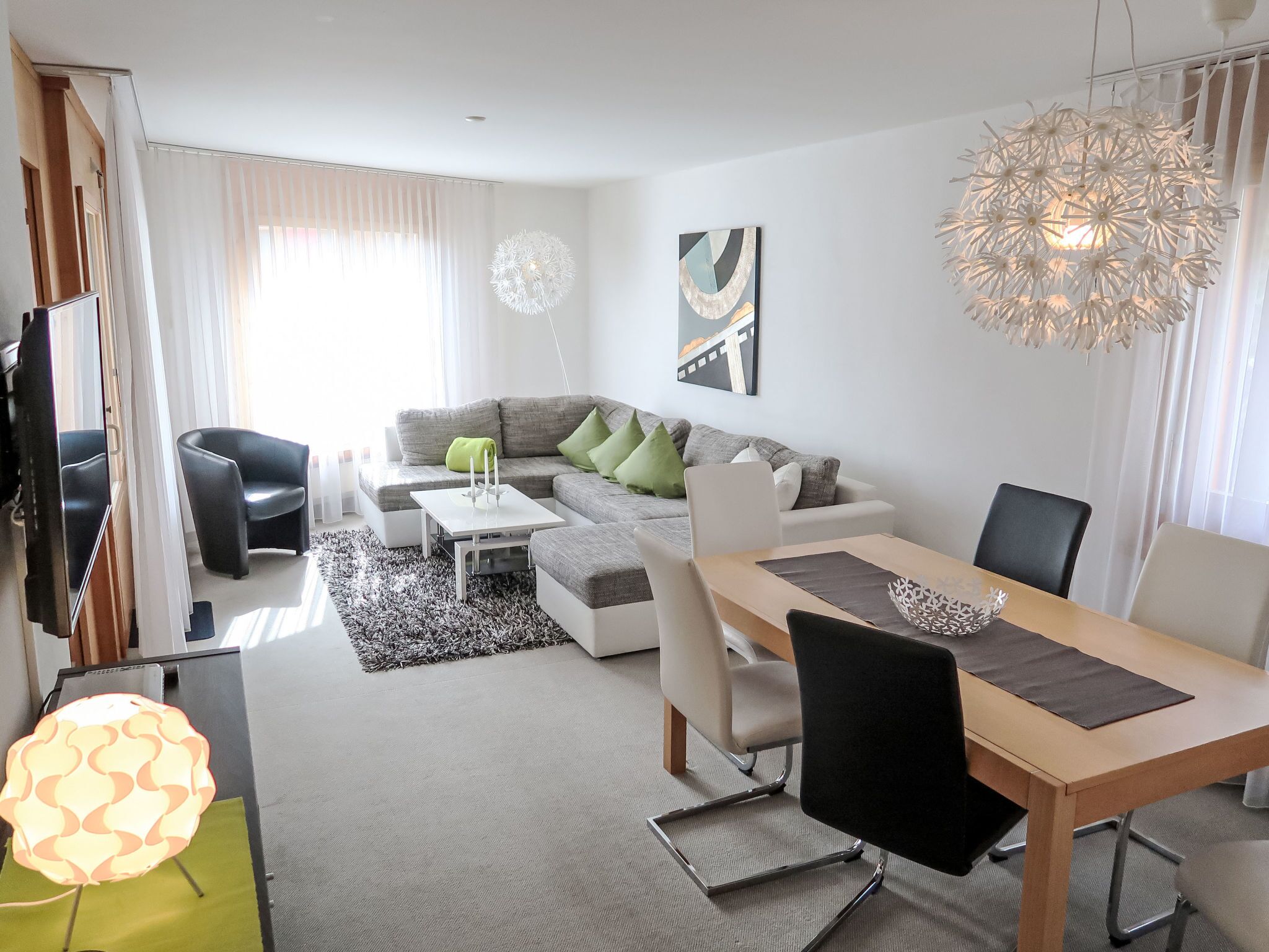 Una sala de estar moderna con sofá, mesa de centro y mesa de comedor.