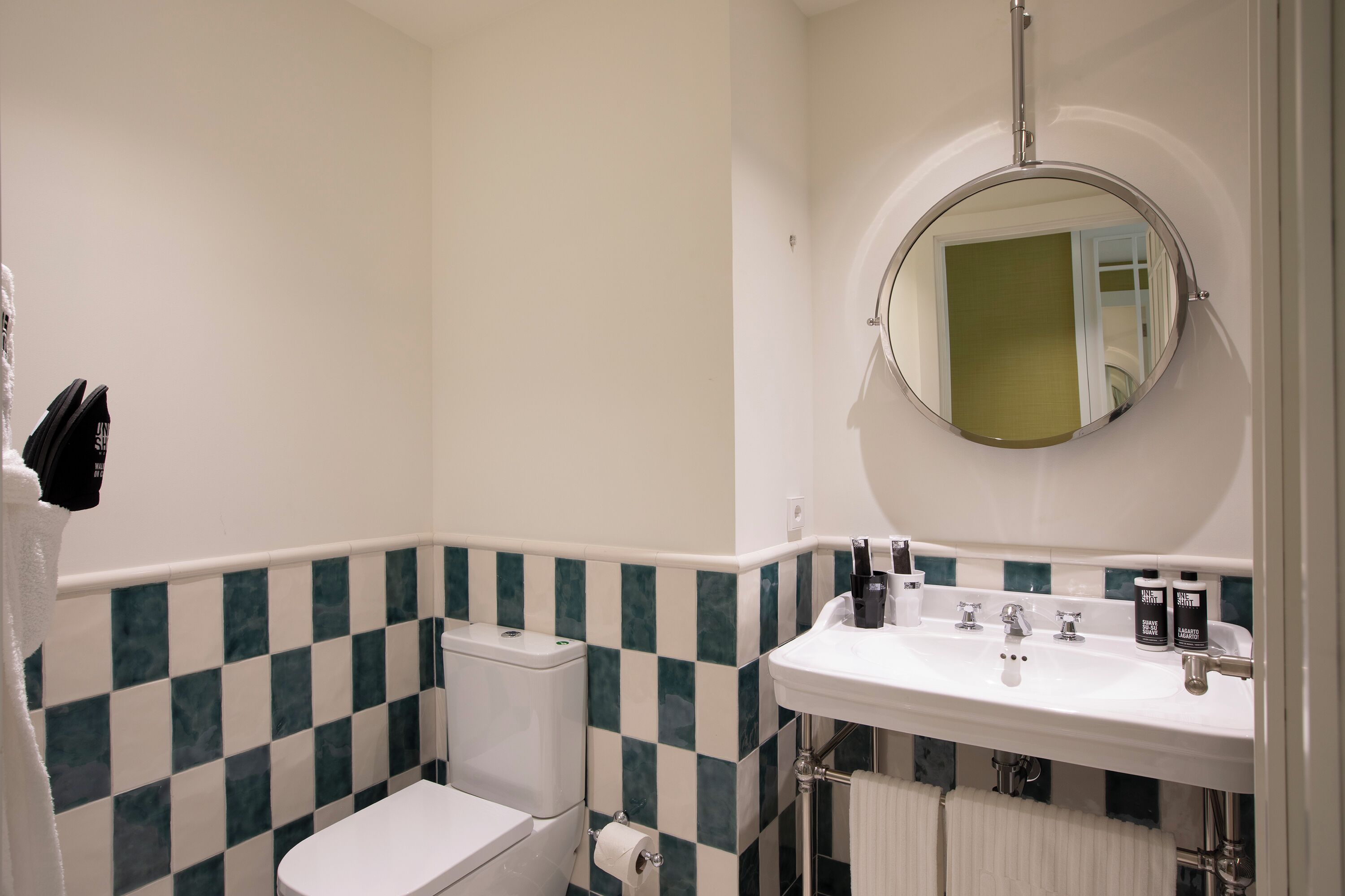 Une salle de bain avec des toilettes, un lavabo et un miroir.