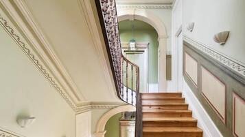Eine prächtige Treppe mit Holzausstattung und einer Balustrade, die zu einer oberen Ebene führt.