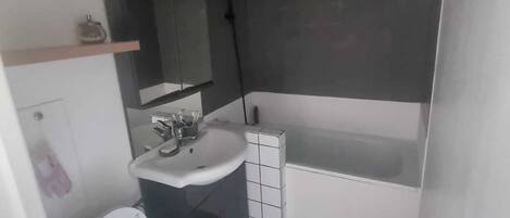 Un baño moderno con inodoro, lavamanos y bañera.