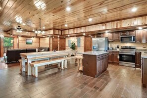 Enjoy meal preparation and dining in this well-equipped kitchen with a central island, refrigerator, microwave, and oven.