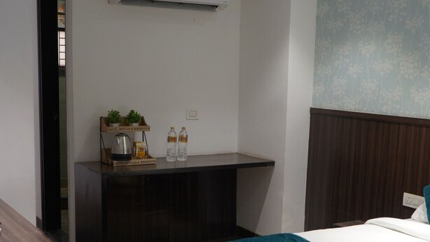 A modern hotel room with a bed, a desk, and a ceiling fan. - Qotel Hotel Rajouri Garden (New Delhi)