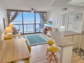 Enjoy a room with a sea view, dining area, and bar, featuring a television and comfortable seating.