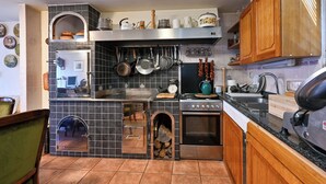A kitchen with a tiled backsplash, wooden cabinets, a stove, and a sink. - Hunting Lodge Hills Retreat (Velika Pisanica)