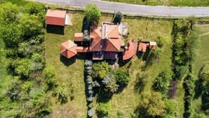 An aerial view of a house with a red roof, surrounded by greenery and a road. - Hunting Lodge Hills Retreat (Velika Pisanica)