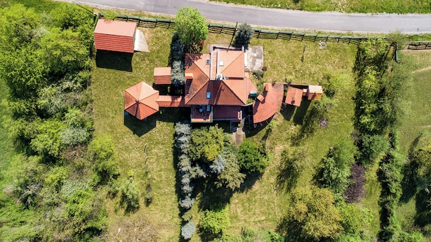 An aerial view of a house with a red roof, surrounded by greenery and a road. - Hunting Lodge Hills Retreat (Velika Pisanica)