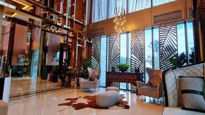 A spacious lobby with a high ceiling, large windows, and modern furniture. - Pattaya Seaview Beachfront Skypool Copacabana Jomtien Condo (Pattaya City)