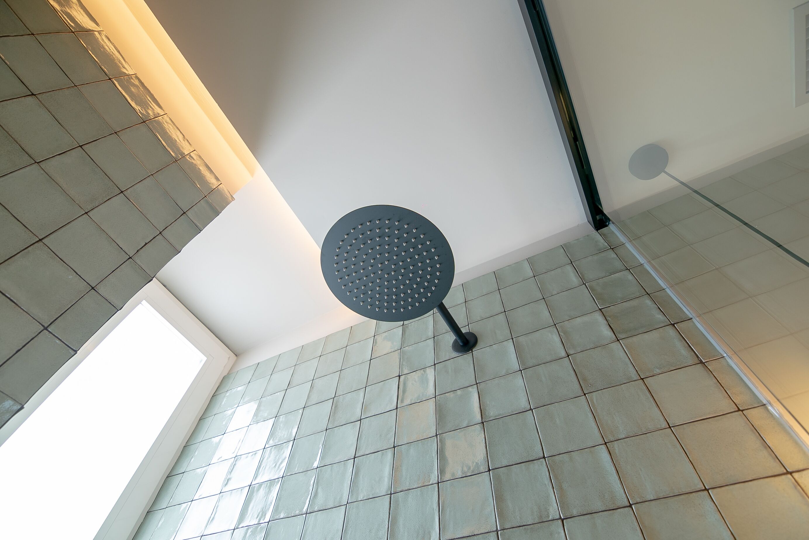 A ceiling with a circular light fixture and a skylight.