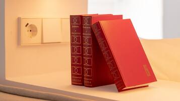 Una estantería con tres libros rojos.