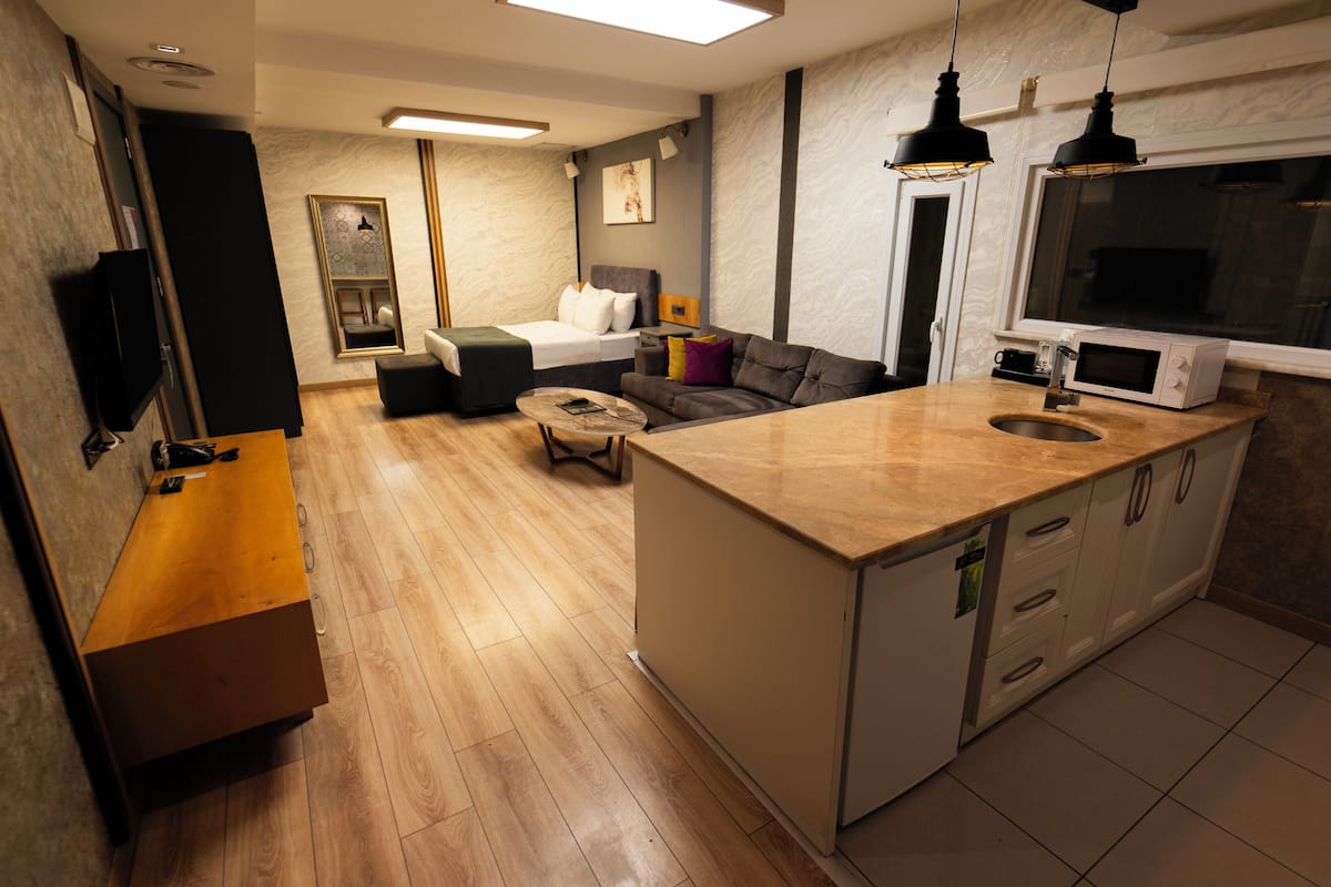 A modern kitchen with a built-in microwave, a wooden countertop, and a sink.
