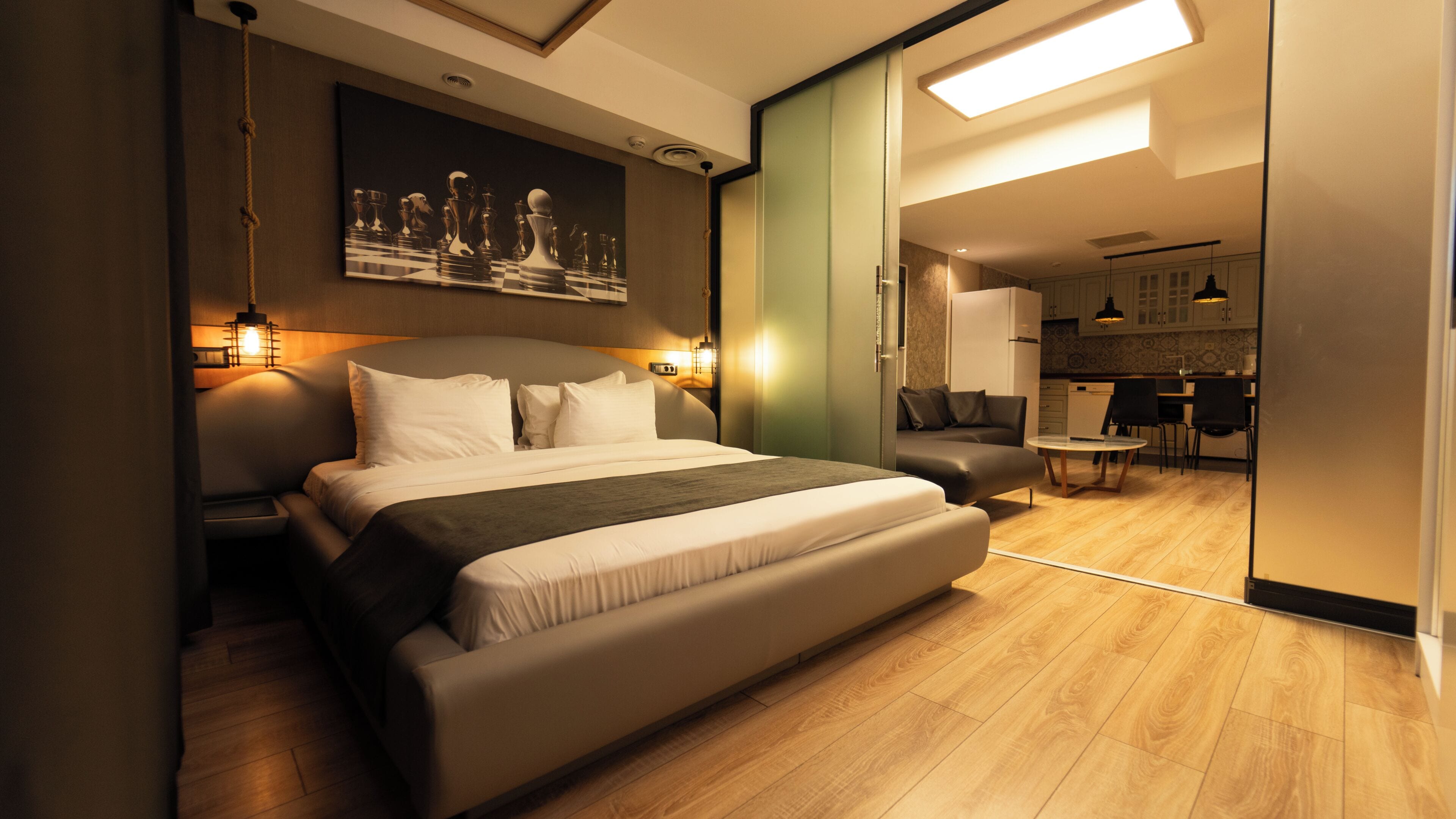 Ein modernes Hotelzimmer mit einem großen Bett, einem Essbereich und einer Küche.