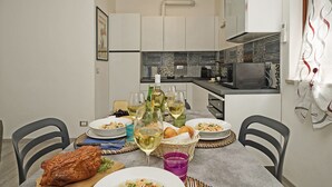 Eine moderne Küche mit weißen Schränken, einer Mikrowelle und einem Essplatz, der für eine Mahlzeit gedeckt ist.