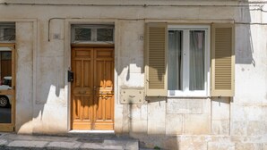 A building with a wooden door and a window with shutters.