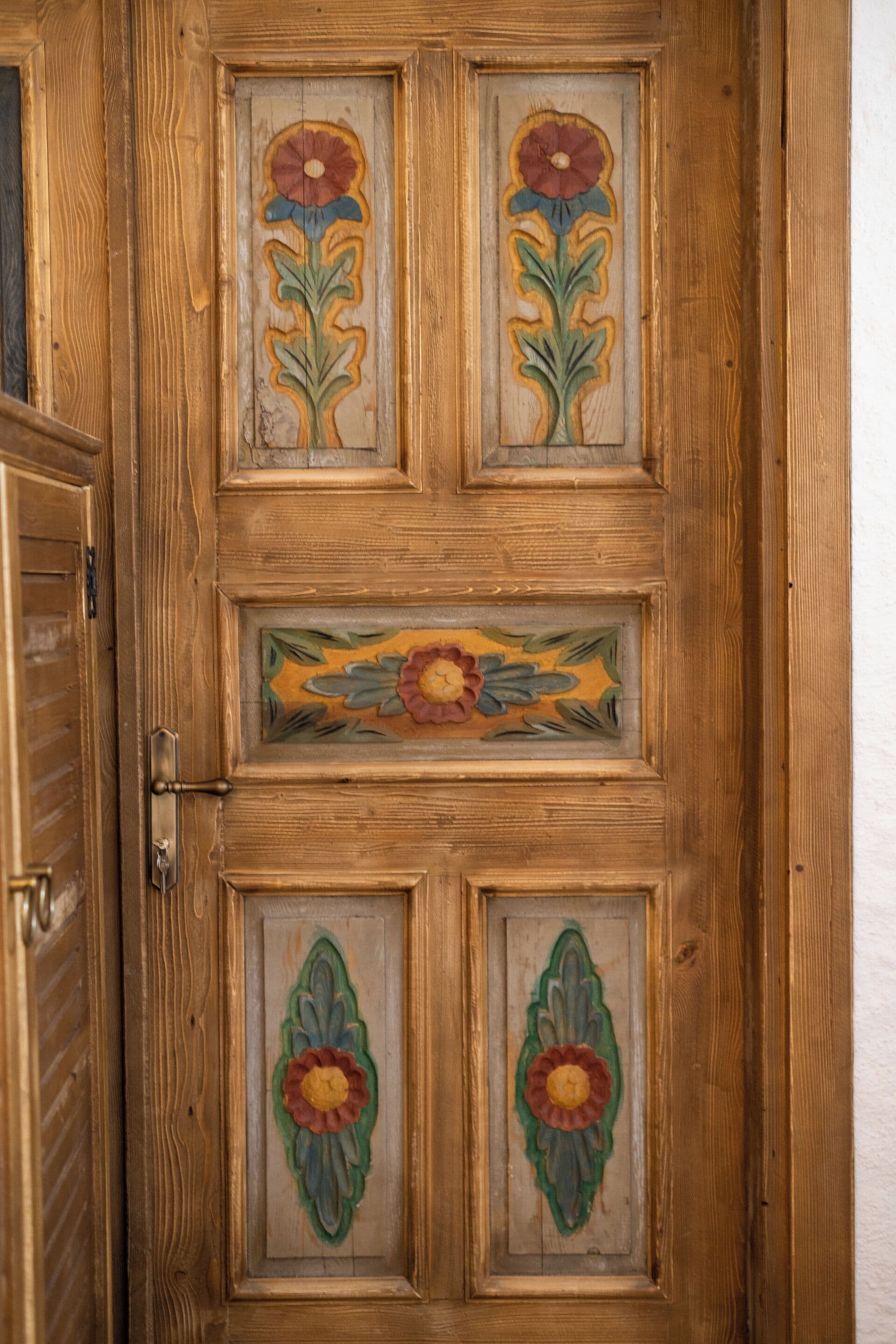 Une porte en bois ornée de motifs floraux.