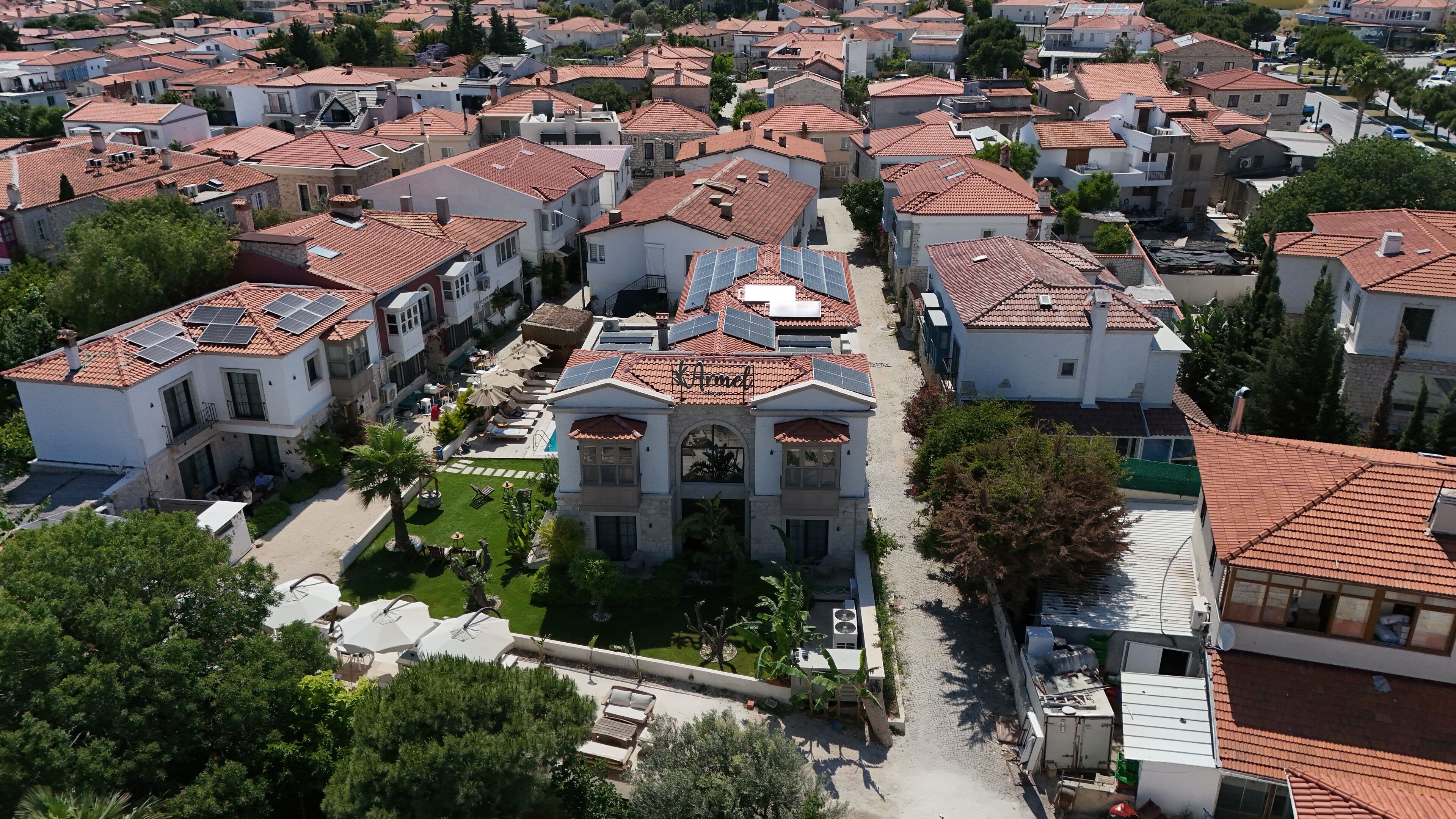 Un barrio residencial con varias casas, cada una con techos de tejas rojas y paredes blancas.