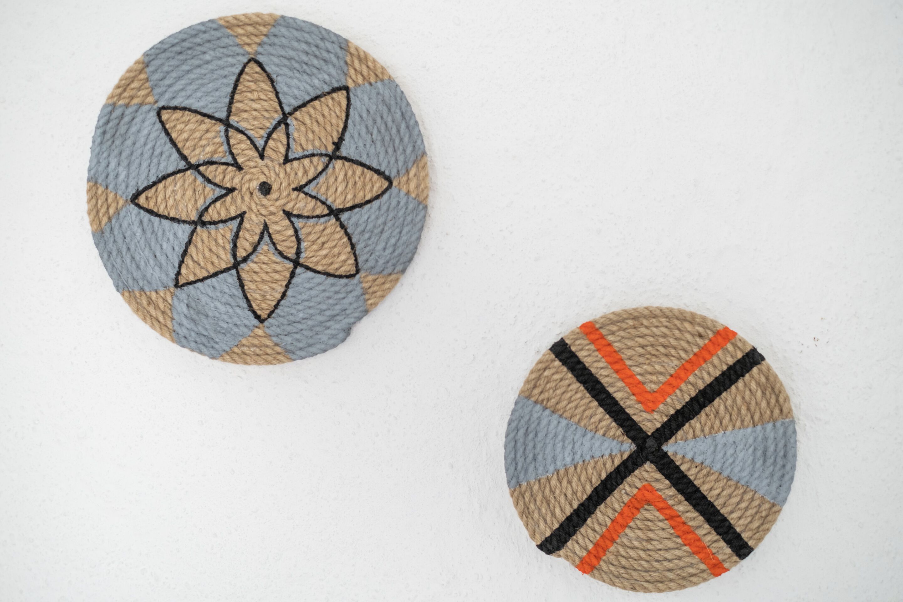 Two circular woven coasters with different patterns.