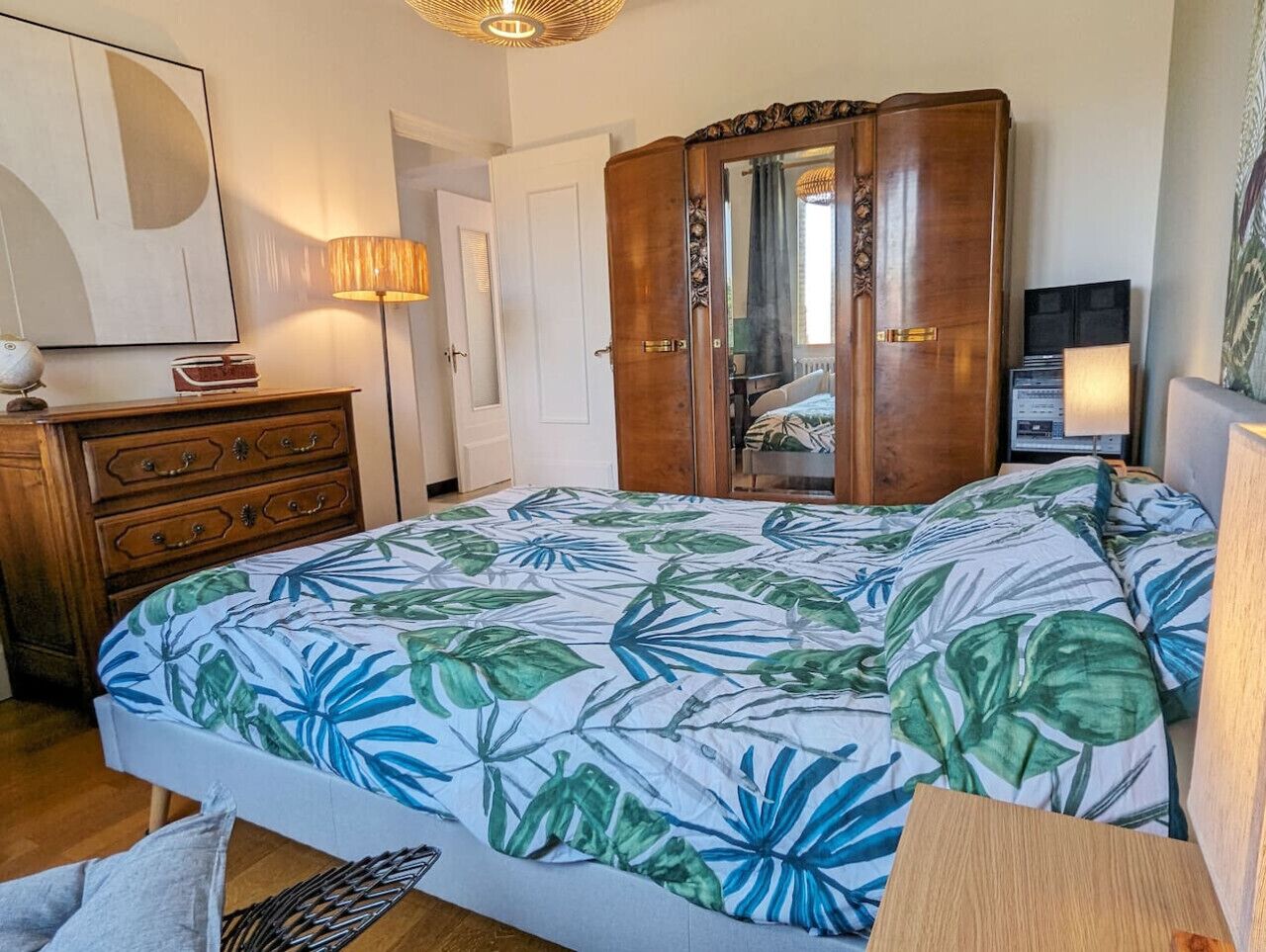 Ein Schlafzimmer mit einem Bett, einem Holzschrank und einem Spiegel.