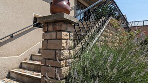 A staircase with a terracotta pot on the landing, leading to a balcony with a wrought iron railing. - Renovated French House - 2 bedroom with A/C (Brignais)