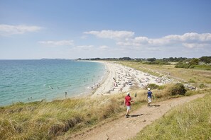 A beach with a dirt path leading to the water, people swimming, and a clear sky. - Relax and garden - Sleeps 6 - 550m from the beach (Saint-Gildas-de-Rhuys)