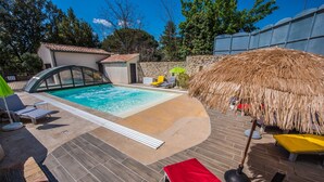 A swimming pool with a thatched roof and lounge chairs. - Gîte Standing Avec Jacuzzi Privatif (Allègre-les-Fumades)