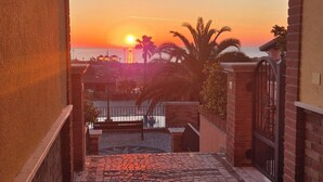 Un camino adoquinado que lleva a una vista del atardecer a través de un arco.
