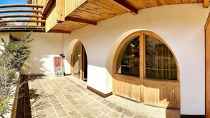 A building with a stone-paved courtyard, wooden balconies, and arched windows. - The perfect retreat for those seeking peace, comfort, sports and nature (Corvara in Badia)