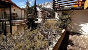 A residential area with a view of snow-capped mountains, wooden fences, and a mix of residential buildings. - The perfect retreat for those seeking peace, comfort, sports and nature (Corvara in Badia)