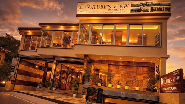 Un hôtel appelé « Vue sur la nature », doté d’un design moderne, de grandes fenêtres et d’une entrée accueillante.