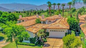 A residential property with multiple houses, a well-maintained lawn, and a clear view of the surrounding landscape.