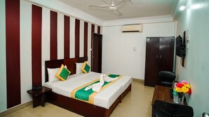 Une chambre d’hôtel équipée d’un lit, d’un bureau, d’une chaise, d’une télévision et d’un appareil de climatisation.