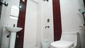 Une salle de bain avec un lavabo blanc, des toilettes et une douche.