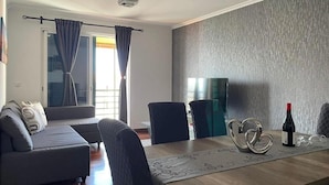 Een moderne woonkamer met een bank, een eettafel en stoelen.