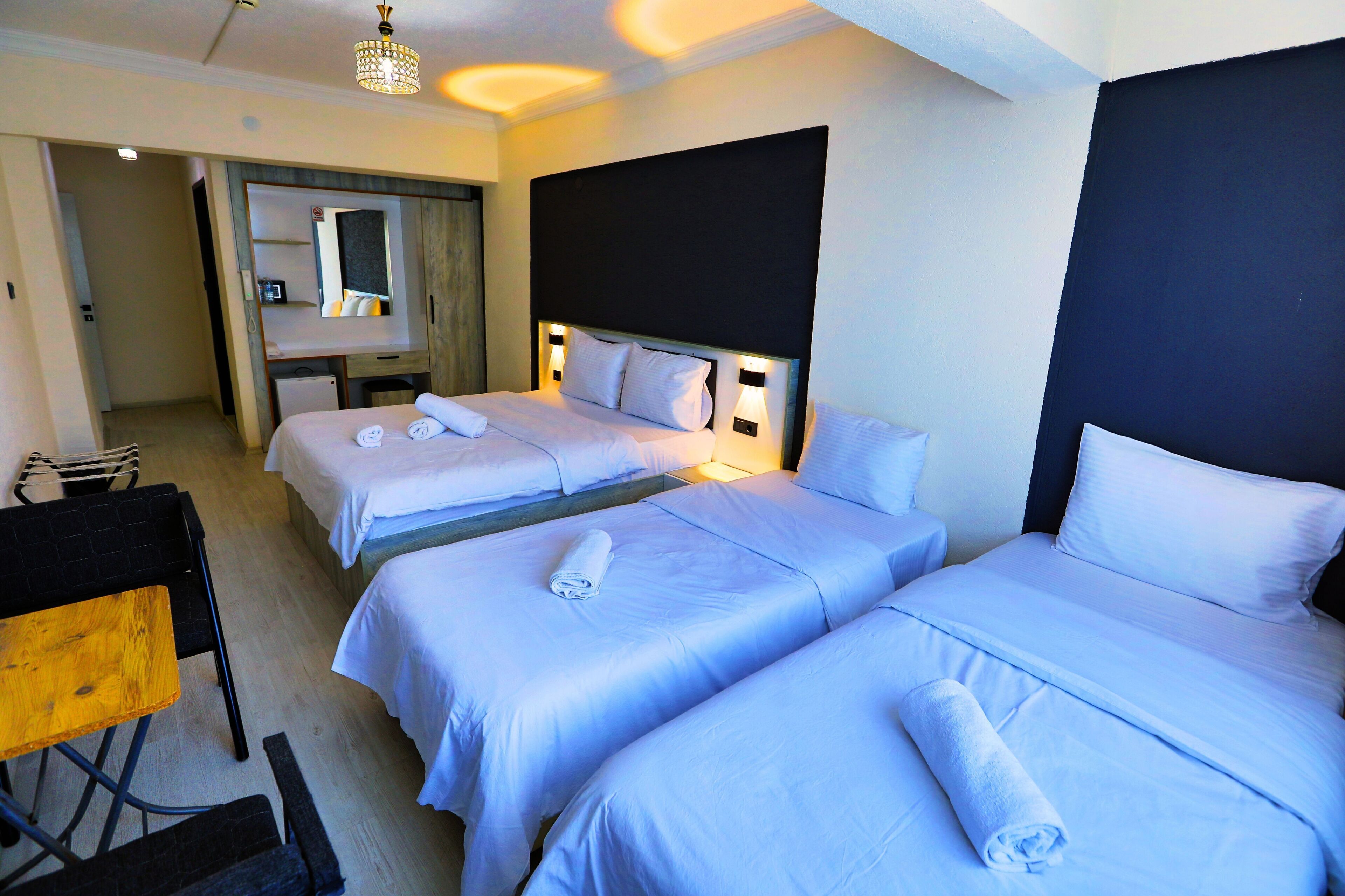A hotel room with two beds, a desk, and a chair.