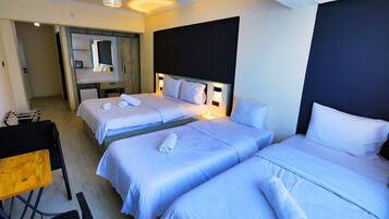 A hotel room with two beds, a desk, and a chair.