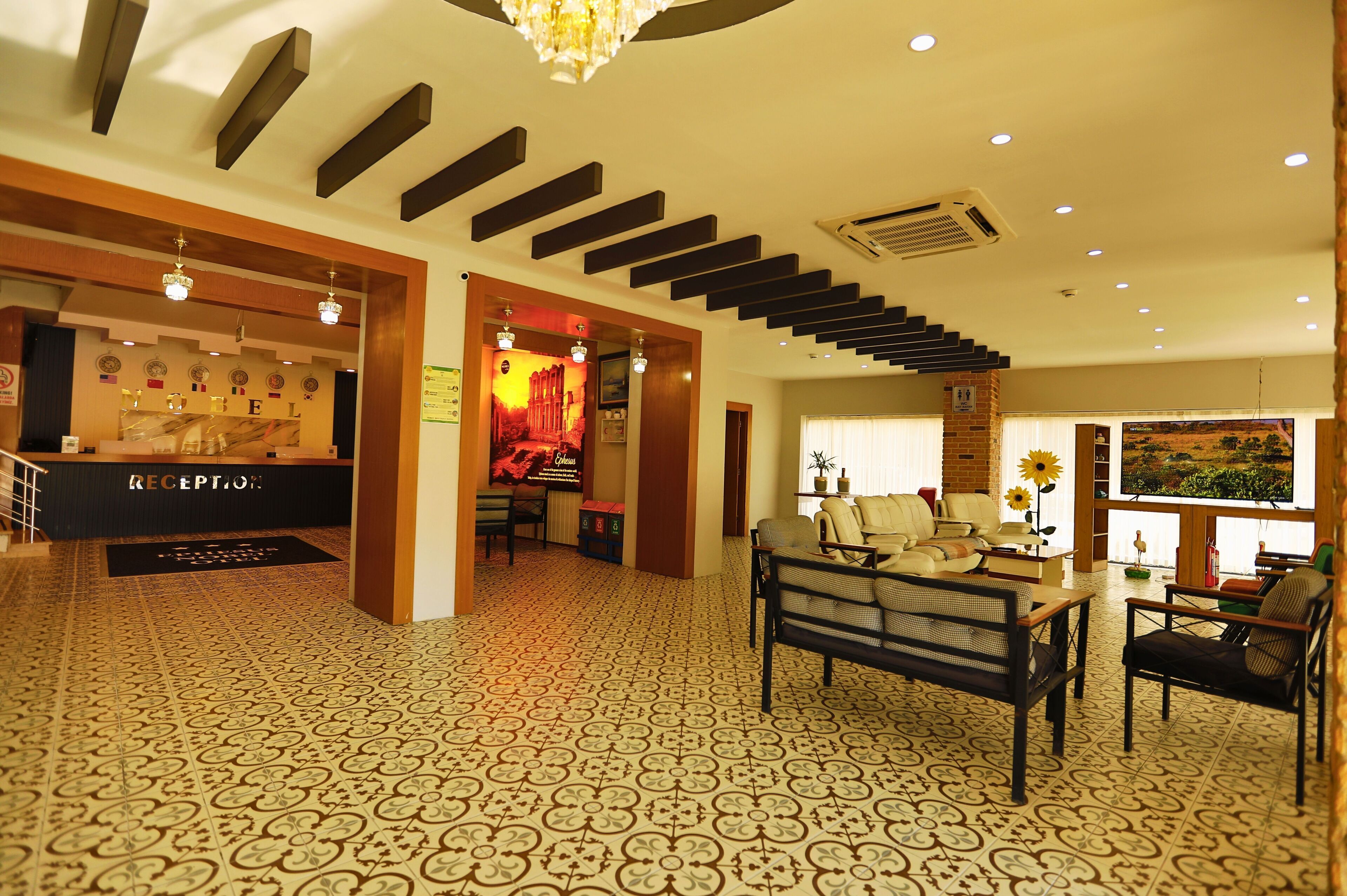 A reception area with a reception desk, patterned carpet, and a staircase leading to upper floors.