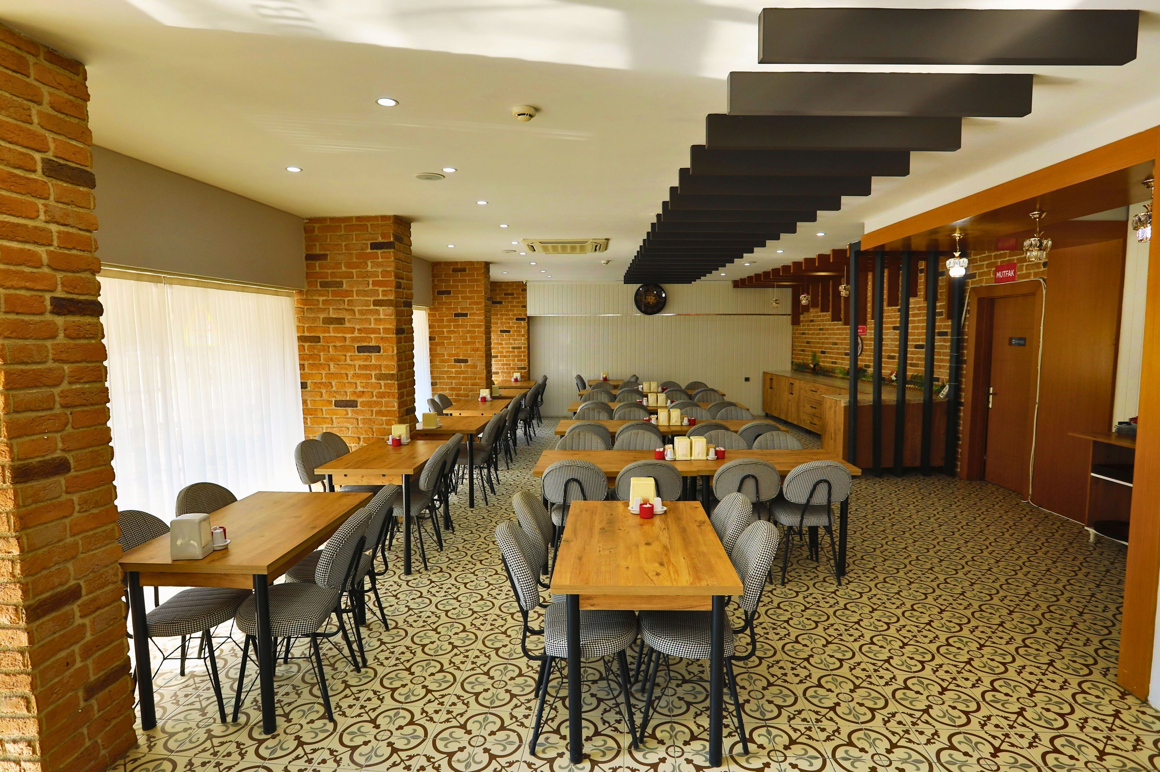 A restaurant with brick walls, wooden tables, and a patterned floor.