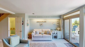 Una sala de estar acogedora con un sofá, una mesita y un cartel que dice 'Jekyll Island'.