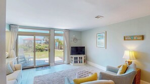 A living room with a TV, sofa, and a lamp.