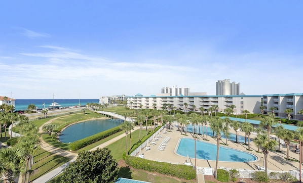 Ein Resort mit mehreren Schwimmbecken, einem Golfplatz und Blick auf den Ozean.